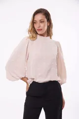 Blusa color beige con cuello mao, mangas 3/4 abullonadas y textura de lunares en relieve.