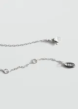 Collar de acero inoxidable con cadena fina eslabonada y dije colgante en forma de esfera irregular.