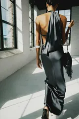 Vestido largo satinado color gris oscuro, con cuello halter, hombros descubiertos y cierre en la espalda con cremallera oculta.