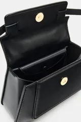 Bolso de mano tipo city color marrón, con diseño estructurado, costuras a la vista en contraste y detalles de hebillas metálicas decorativas. Cuenta con asa superior, cierre imantado y correa de bandolera ajustable.