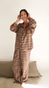 Conjunto de pijama a cuadros con ribetes en color lila, compuesto por camisa de manga larga con botones y pantalón largo.