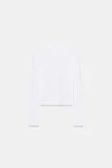 Camiseta de manga larga confeccionada en algodón 100%, con cuello redondo y cierre frontal mediante una hilera de botones pequeños.