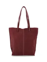 Cartera tipo tote bag de gamuza color bordó, con doble asa larga para el hombro y costura vertical central con detalle de etiqueta grabada.