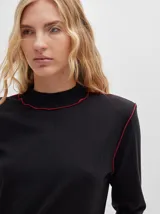 Polera básica de algodón en tejido rib, color turquesa, de manga larga, con hombreras y detalles de pespuntes en color contrastante en las terminaciones y el cuello.