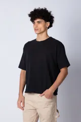 Remera de corte boxy y holgado, confeccionada en algodón pesado, con cuello redondo y diseño liso.