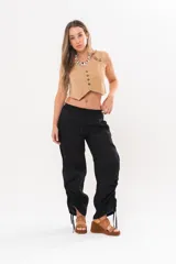 Pantalón holgado negro de lino con cintura elastizada y cordones ajustables en los laterales de las piernas.