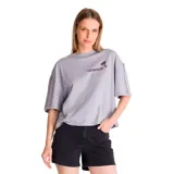 Remera de corte oversize color gris lila, con cuello redondo y mangas cortas. Presenta un estampado gráfico en el pecho con la palabra 'CATERPILLAR' y una palmera pequeña.