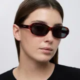 Lentes de sol con montura de diseño rectangular y bordes redondeados en estampado carey marrón, con cristales polarizados en color negro.