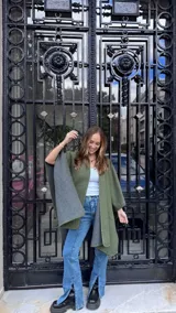 Ruana abierta de diseño reversible, con un lado en color verde militar y el otro en gris, con terminación de ribete.
