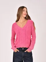 Buzo de tejido de punto color verde menta, con cuello en V y diseño de trenzas en el frente y mangas. Presenta un efecto desgastado o lavado.