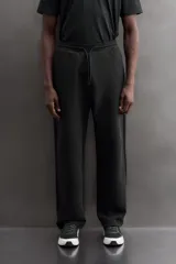 Pantalón jogger relaxed fit Zara Athleticz de tejido técnico compacto elástico con mezcla de algodón. Presenta cintura elástica ajustable con cordón, bolsillos laterales en la cadera, bolsillo trasero con cierre de cremallera, bajo ajustable con elástico y detalle de logo estampado en la pernera.