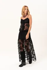 Pollera larga de encaje negro con silueta fluida y diseño asimétrico. Presenta un forro interno hasta la altura del frunce, dejando la parte inferior con transparencias que aportan movimiento.