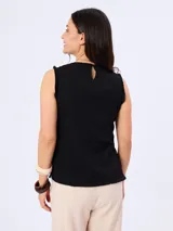 Blusa negra sin mangas, con escote en V y detalles de flecos en los bordes y costuras.