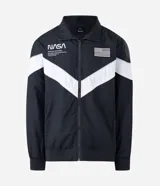 Campera deportiva de poliéster con diseño de bloques de color en negro y blanco. Presenta cuello alto, cierre frontal con cremallera y parches de la NASA y la bandera de Estados Unidos en el pecho.
