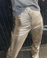Pantalón de cuero sintético color oro rosado metalizado, de corte recto y tiro alto, con cierre frontal y botón nacarado.