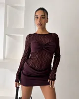 Vestido corto de diseño combinado, con cuerpo de encaje negro de manga larga y falda de ecocuero negro con corte asimétrico y detalle de fruncido lateral.