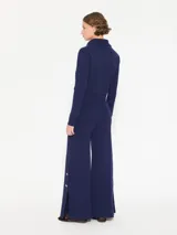 Pantalón azul de hilado frío, tejido cerrado y pesado, largo a los tobillos, con botones dorados en los laterales.