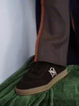 Championes de gamuza color borgoña, beige y naranja con cordones.