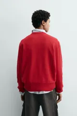 Jersey de corte regular fit, tejido en una mezcla de lana y cashmere, con cuello en pico y manga larga. Presenta acabados en rib en puños y bajo.