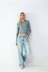 Jean de tiro alto confeccionado en denim de corte recto, con diseño clásico de cinco bolsillos y cierre frontal con cremallera y botón metálico.