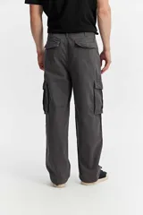 Pantalón cargo de fit baggy color beige, con piernas amplias, bolsillos laterales con tapa y costuras decorativas.