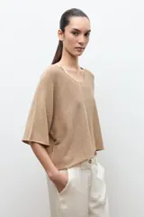 Sweater oversized de punto color verde, con escote en V y mangas cortas holgadas.