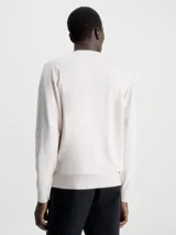 Sweater de hombre Calvin Klein de corte regular, color beige claro, con cuello redondo y puños y bajo de canalé. Presenta una pequeña etiqueta con el logo de la marca sobre el bajo.