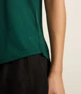 Musculosa deportiva de microfibra texturizada con diseño de cuadraditos, cuello redondo, breteles anchos y bajo redondeado.