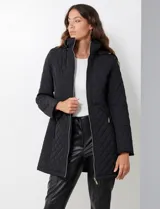 Campera capitoneada de corte largo con diseño de costuras multidireccionales, combinando un patrón de rombos en el cuerpo con capitoneado lineal en laterales y hombros. Cuenta con cierre frontal completo, cuello alto reforzado, capucha desmontable ajustable con cordones y bolsillos laterales con cierre invisible.