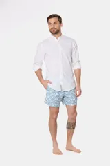 Short de baño celeste con estampado floral blanco, cintura con elástico y cordón regulable, bolsillos laterales y suspensor de malla fina.