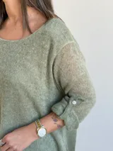 Sweater de tejido de punto color verde, de corte holgado y acampanado, con cuello redondo y mangas largas con presilla para arremangar.
