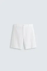 Bermuda azul marino de corte regular fit, confeccionada en tejido de algodón y lino. Cuenta con bolsillos frontales y traseros, cierre frontal con cremallera y botón.