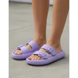 Sandalias chancletas de goma color beige con diseño texturizado en la suela, doble tira ajustable con hebillas y estilo slip-on.