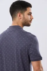 Remera polo de manga corta en color azul marino, con estampado sutil de pequeños motivos geométricos, cuello camisero y cartera con tres botones.