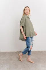 Camisa de lino color verde militar, de corte amplio y caída ligera. Cuenta con cuello camisero, botones en el frente y mangas 3/4 que se pueden arremangar.