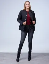 Campera capitoneada azul marino con cuello y ribetes en cuero marrón, marca Michael Kors. Abertura central con botones metálicos dorados, bolsillos verticales delanteros y logo metálico en el brazo.