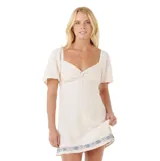 Vestido corto color blanco roto, con escote cuadrado y nudo central en el busto. Posee mangas cortas abullonadas y un borde inferior con bordado geométrico en color azul.