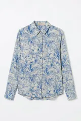Camisa de seda color celeste y beige, con estampado de hojas en tonos azules, cuello camisero, manga larga y cierre frontal de botones.