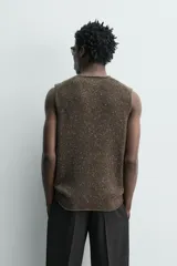 Chaleco regular fit de punto tejido en hilatura con mezcla de lana, color marrón con efecto melange. Cuenta con cuello en V y manga sisa, con acabados acanalados.