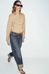 Jeans de tiro medio con corte relax fit y pernera holgada. Presenta diseño de cinco bolsillos, cierre frontal con cremallera y botón, y bajo con vuelta marcada.