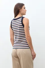 Top sin mangas a rayas horizontales en tonos azul marino, blanco y marrón, con detalle de volados en el cuello y las sisas.