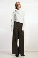Camiseta de manga larga confeccionada en mezcla de algodón y lino, con cuello redondo y detalle de superposición tipo pañuelo en el mismo tejido.