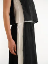 Vestido largo negro de tirantes finos blancos, corte recto y diseño minimalista.
