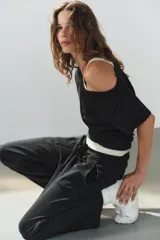Pantalón de algodón negro con tiro medio, cintura elástica, pierna recta y grandes bolsillos laterales aplicados.