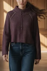 Sweater de punto morado con cierre metálico parcial en el cuello alto y mangas largas.