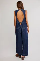 Mameluco enterito de denim azul oscuro, sin mangas, con escote redondo, costuras a contratono y piernas de corte muy ancho y amplio.