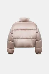 Anorak acolchado de efecto brillante con tejido cortavientos y repelente al agua. Presenta cuello subido, cierre frontal con cremallera, bolsillos delanteros con forro polar y cierre de cremallera, y mangas largas con puños elásticos. El bajo es ajustable con cordones elásticos laterales.