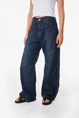 Pantalón jean de corte amplio y relajado, color azul oscuro, con bolsillos traseros grandes y detalles de costuras marcadas.