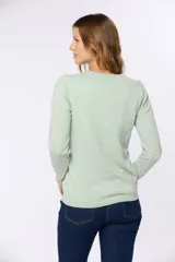 Saco tejido fino de hilo de algodón color beige, con cuello en V, cierre frontal con botones y puños acanalados.