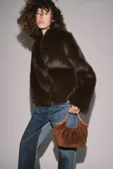 Bolso de hombro formato mini shopper confeccionado en piel, con diseño fruncido, doble asa de mano con pespuntes decorativos y cierre mediante clip metálico.